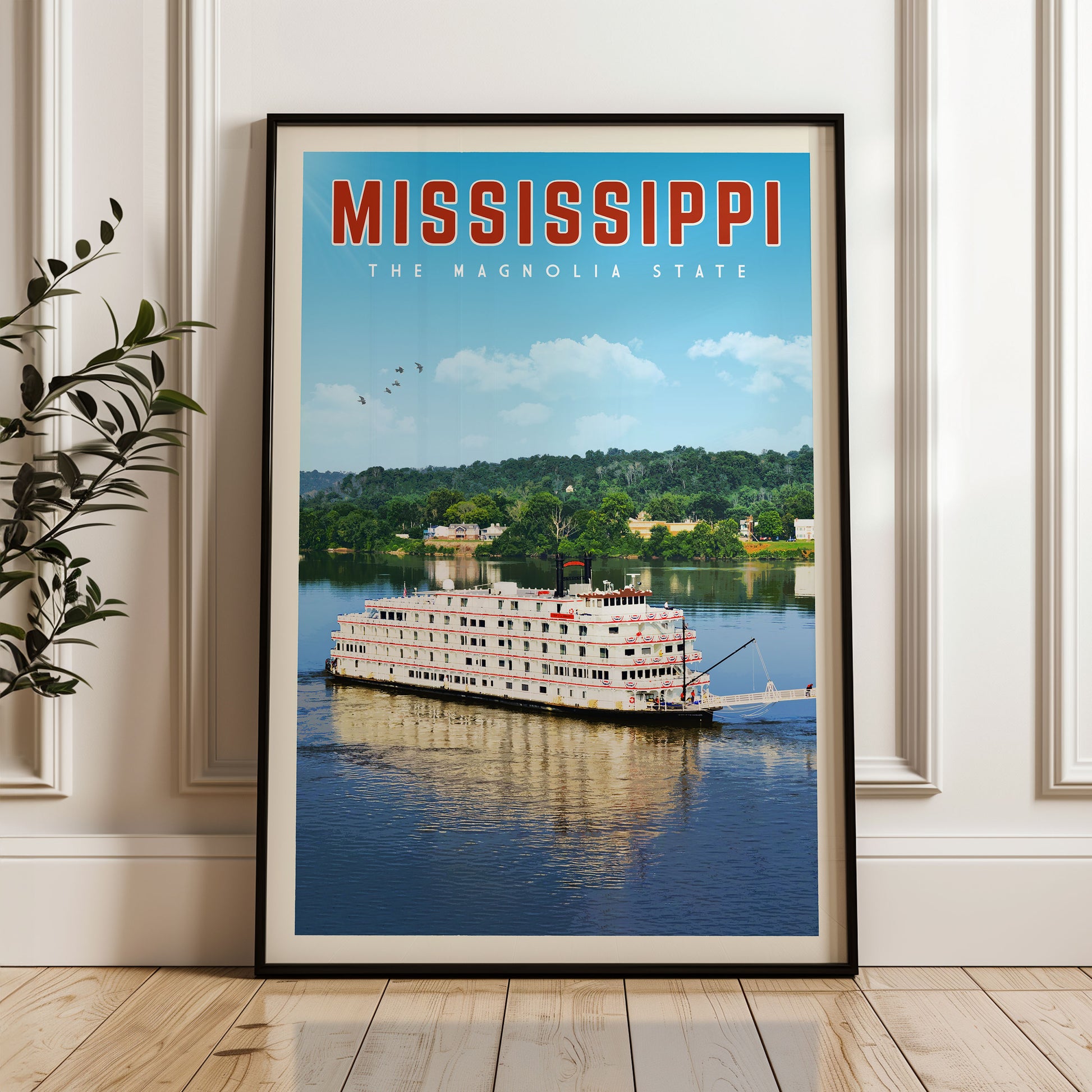 A framed poster of a large white boat on a river, with the text "MISSISSIPPI THE MAGNOLIA STATE" prominently displayed.