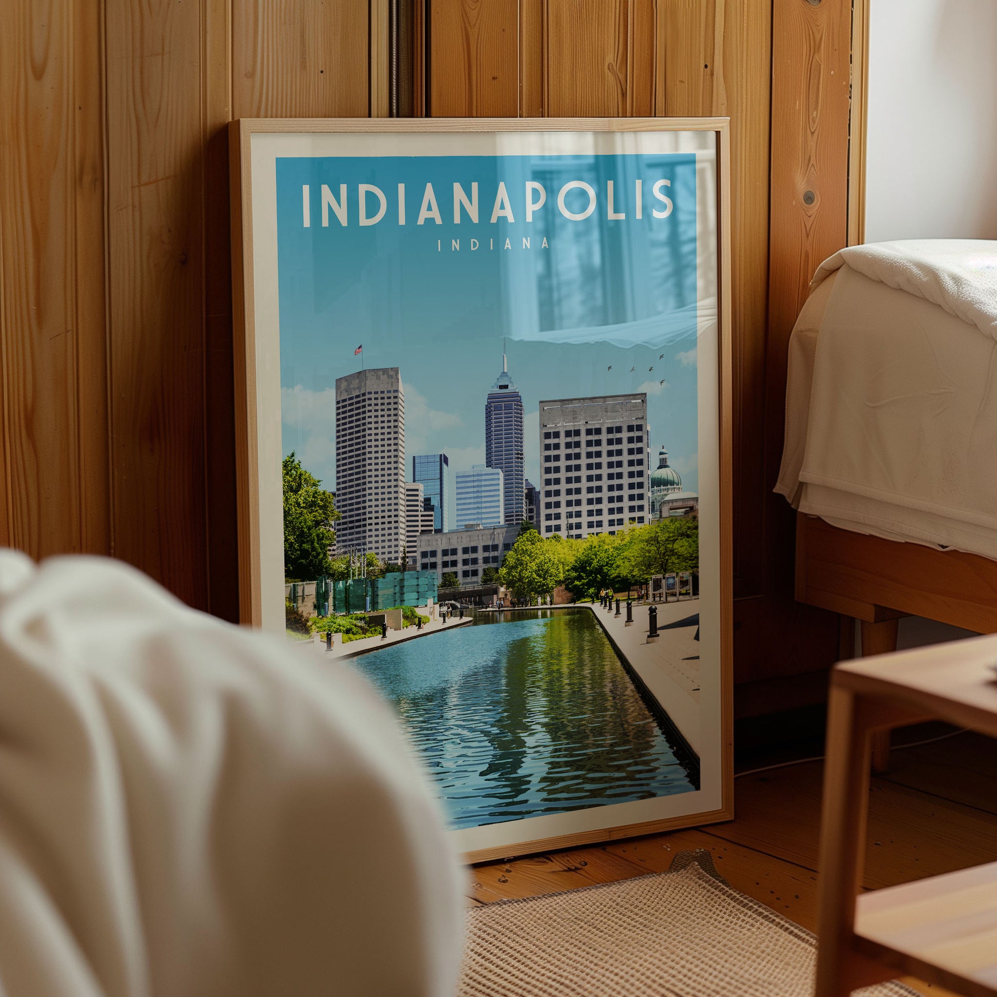 A framed poster of the skyline of Indianapolis, Indiana, with a large body of water in the foreground.