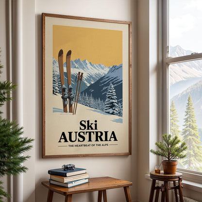 A framed poster of a snowy mountain landscape with skis and trees, hanging on a wall in a room with a window and a small table with books and a plant.