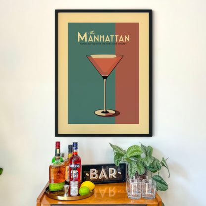 a framed poster of a cocktail glass on a wall above a wooden bar cart with various bottles of alcohol and a potted plant.