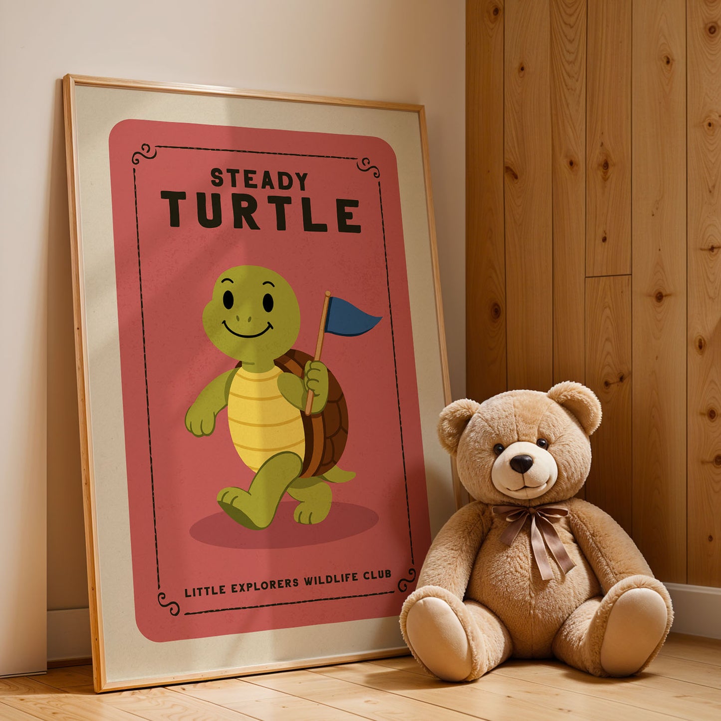 A framed poster of a smiling turtle holding a flag is displayed next to a brown teddy bear on a wooden floor.