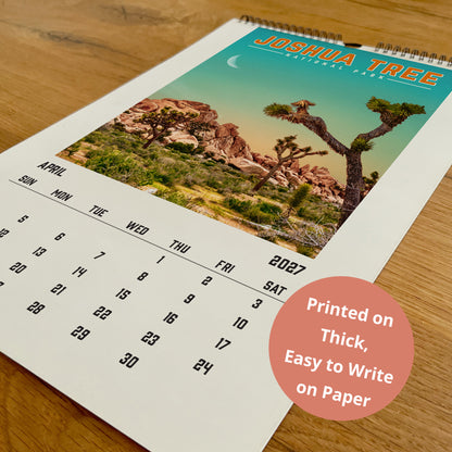 A wall calendar for Joshua Tree National Park, featuring a desert landscape with a crescent moon and a desert tree.