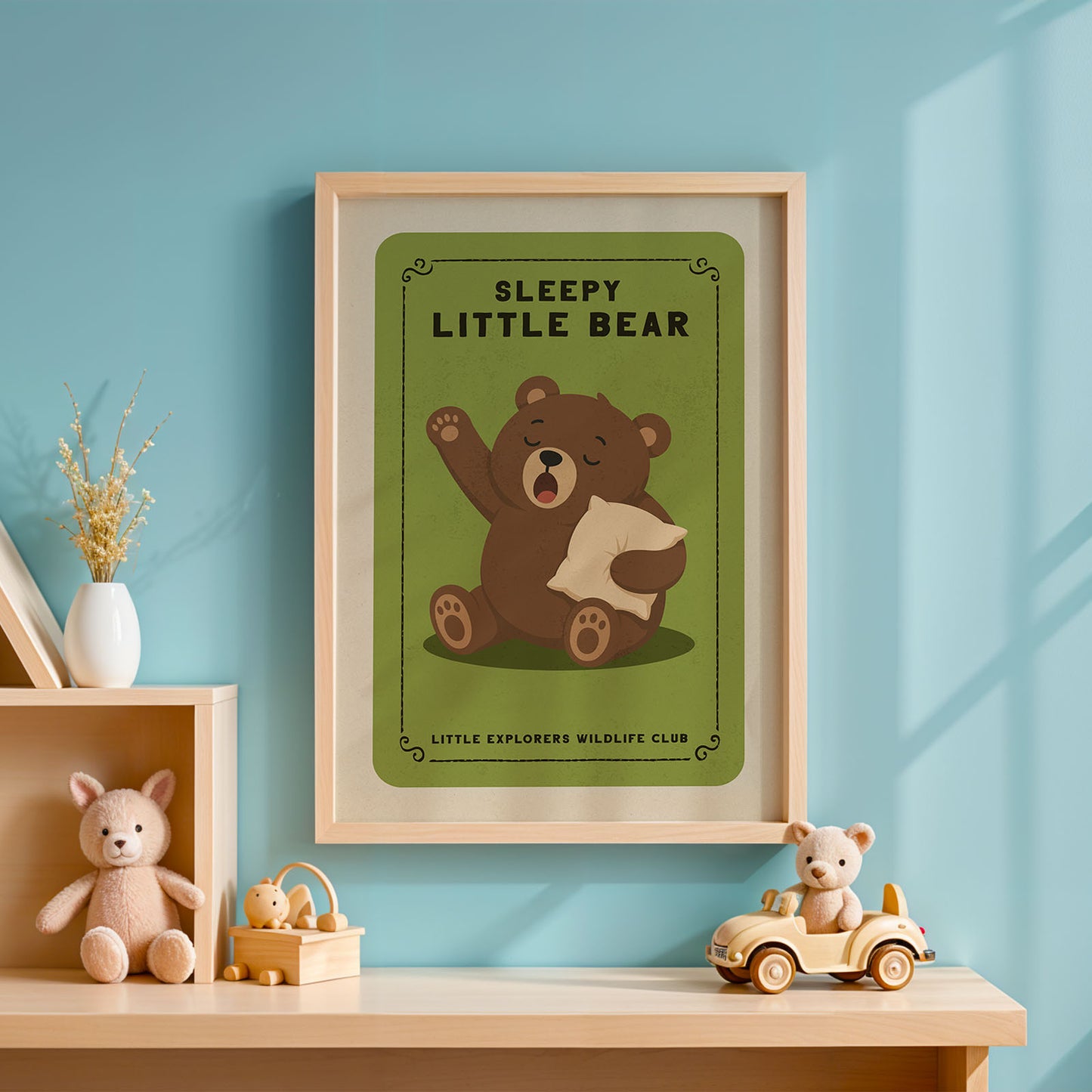 a framed poster of a cartoon bear with the text "SLEEPY LITTLE BEAR" on it, hanging on a blue wall. Below the bear, there is text that reads "LITTLE EXPLORERS WILDLIFE CLUB".