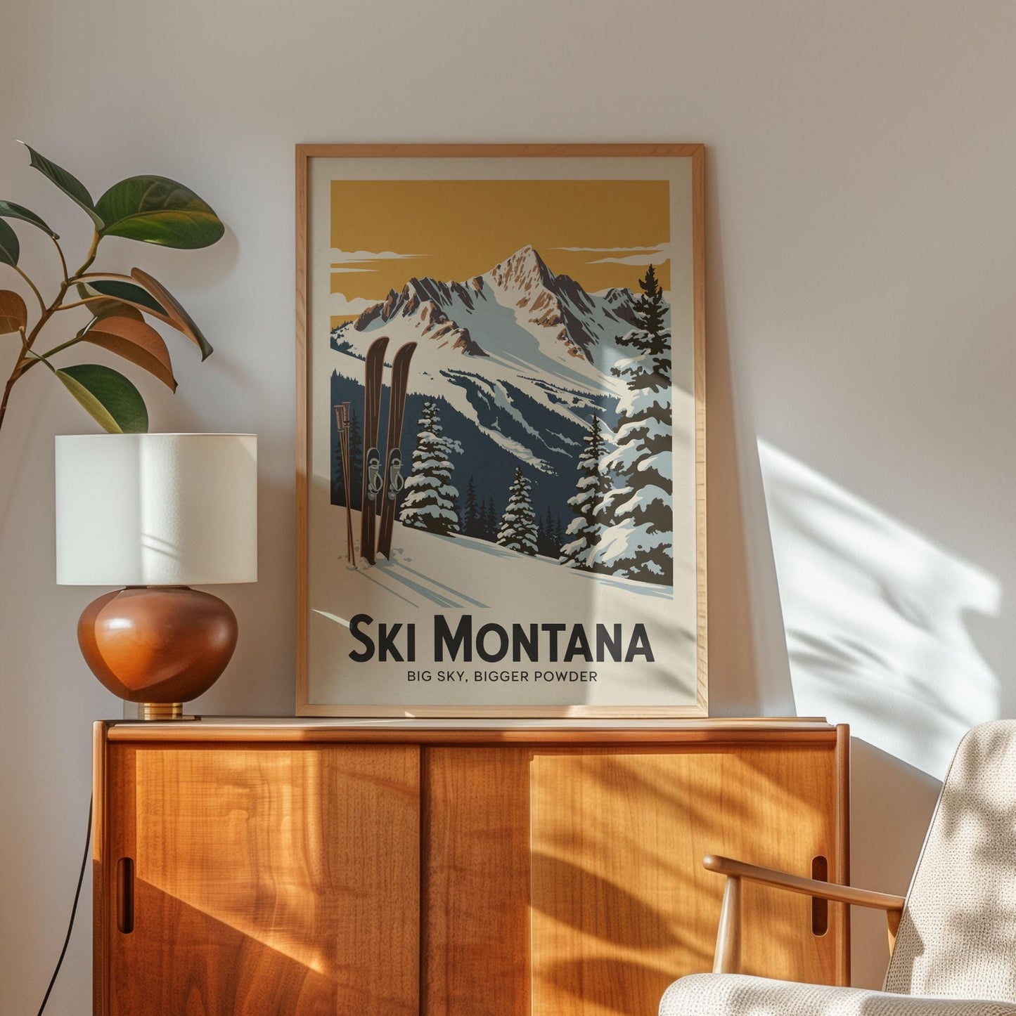 A framed poster of a snowy mountain landscape with skis is displayed on a wooden cabinet, accompanied by a lamp and a plant in the corner of the room.