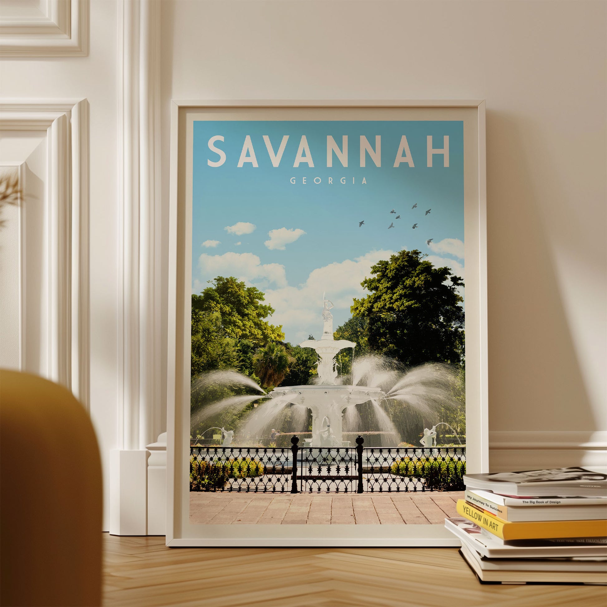 A framed poster of a fountain in Savannah, Georgia, with the text "SAVANNAH GEORGIA" prominently displayed.