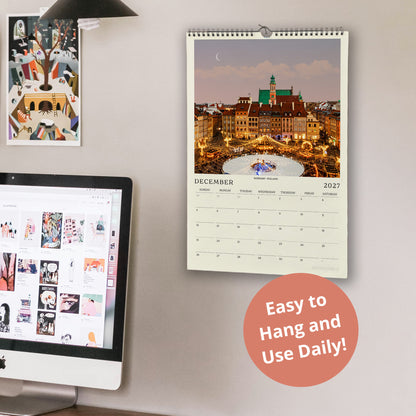a wall calendar with a cityscape photo, a computer monitor displaying a photo gallery, and a desk with a laptop.