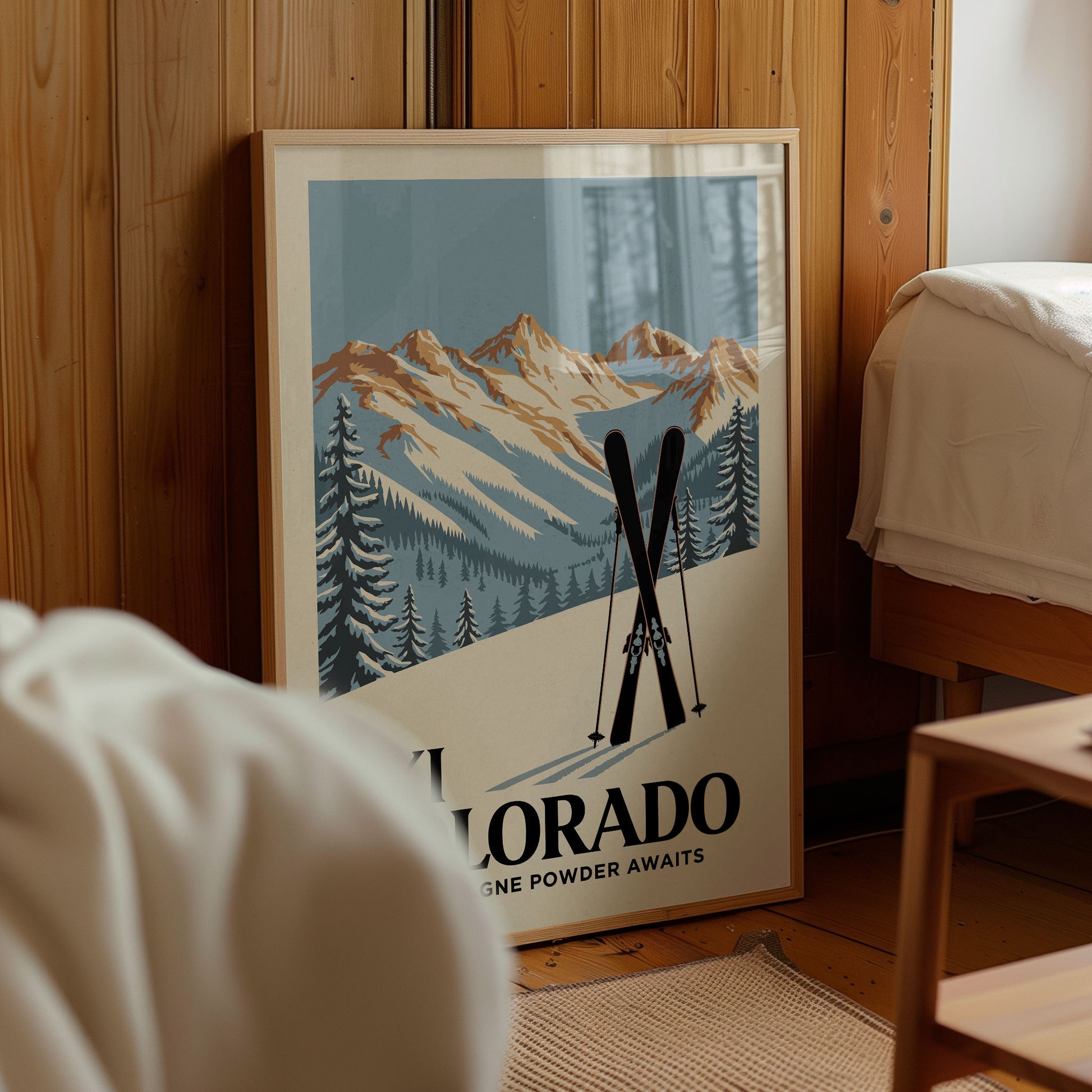 A framed poster of a mountain landscape with ski equipment, advertising "Colorado Powder Awaits".