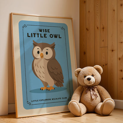 a framed poster of an owl next to a teddy bear, both sitting on a wooden floor.