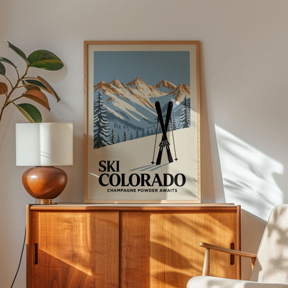 a framed poster of a mountain landscape with skis, placed on a wooden cabinet or shelf.