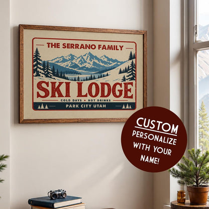 a framed poster of a ski lodge with a mountain landscape, and there is a circular sticker on the wall that says "CUSTOM PERSONALIZE WITH YOUR NAME!"