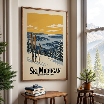 A framed poster of a snowy mountain landscape with skis and pine trees hangs on a wall, with a small table and a potted plant in front of it.