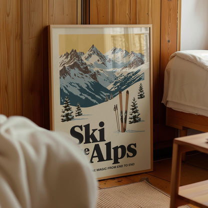A framed poster of a snowy mountain landscape with skis and trees, featuring the text "Ski e alps" and "The magic from end to end".