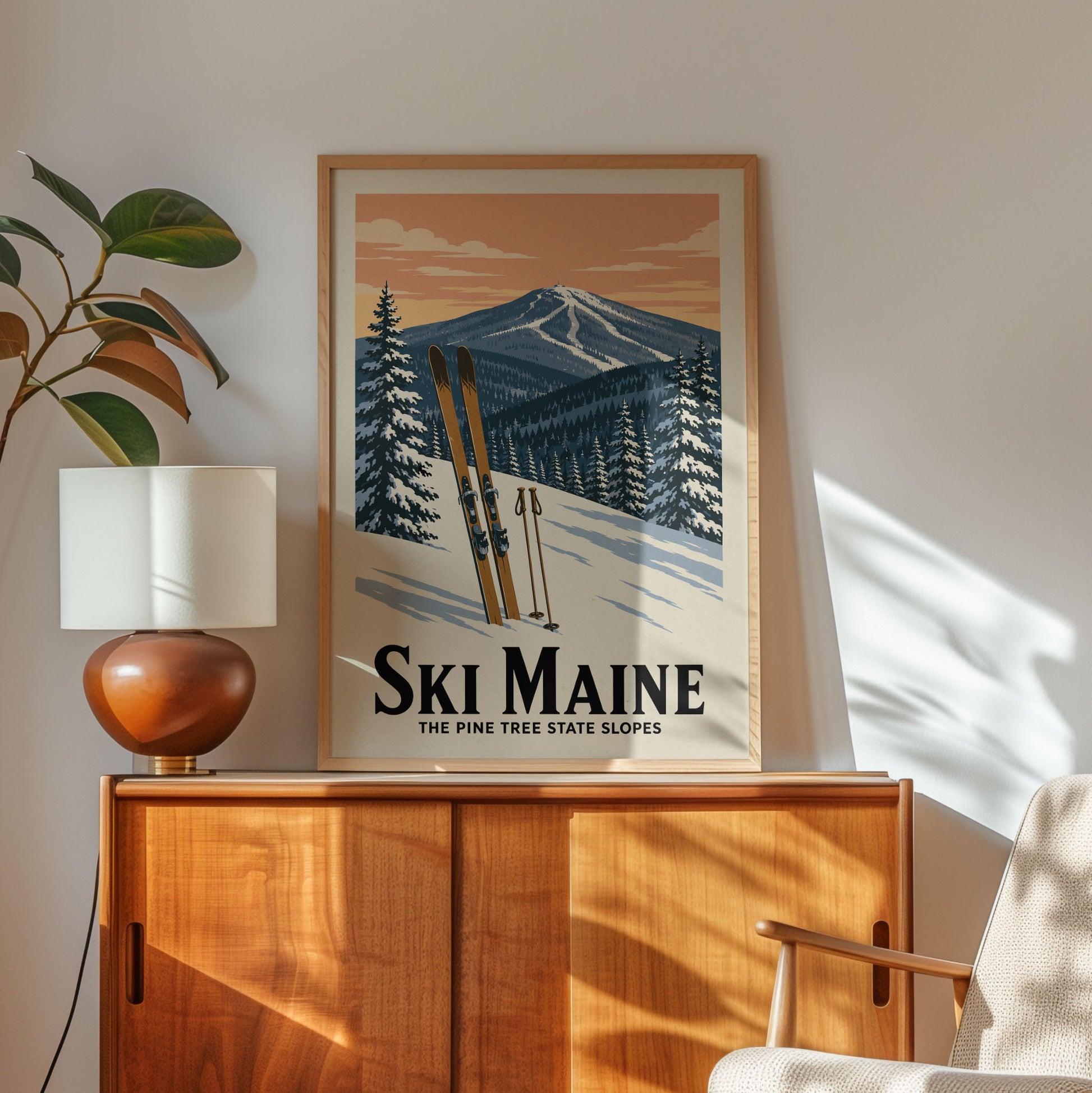 A framed poster of a snowy mountain landscape with skis is displayed on a wooden cabinet, accompanied by a lamp and a plant in the corner of the room.