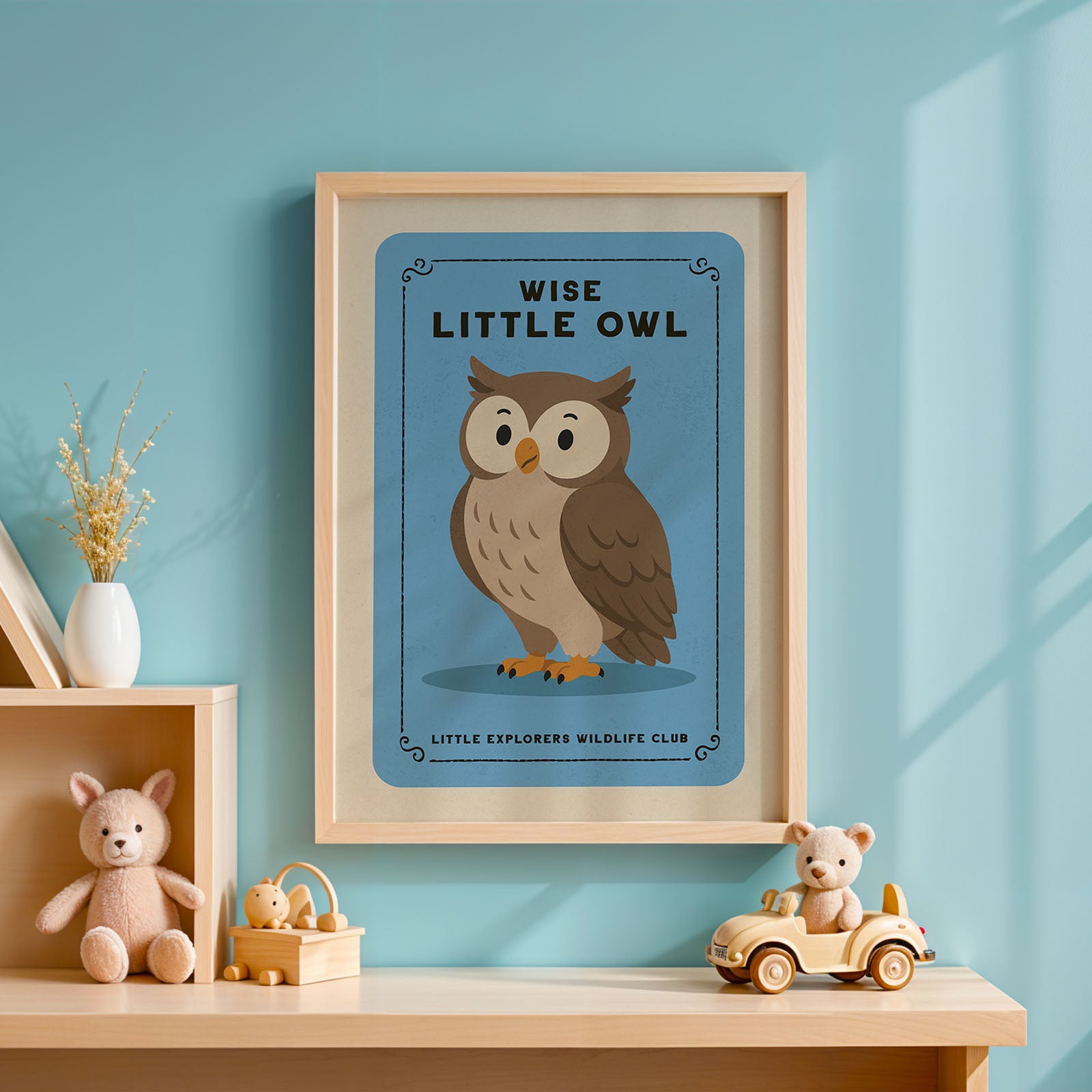 a framed poster of an owl on a blue background, with the text "WISE LITTLE OWL" and "LITTLE EXPLORERS WILDLIFE CLUB" below it. The poster is hanging on a wall, and there are some toys and decorative items placed nearby.