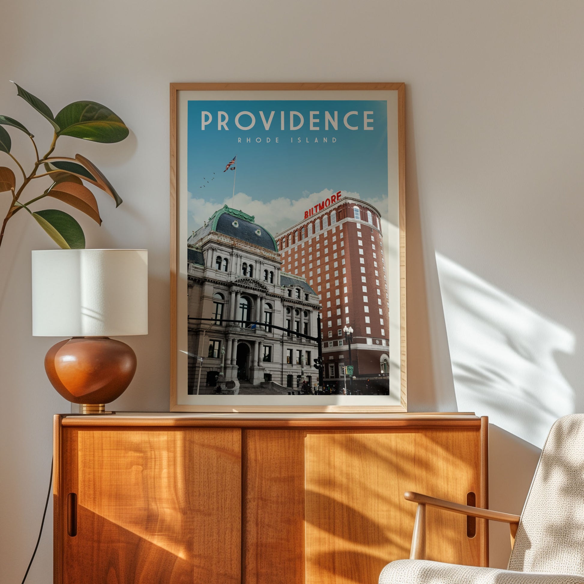 a framed poster of a building with the text "PROVIDENCE RIODE ISLAND" on it, placed on a wooden cabinet or shelf.