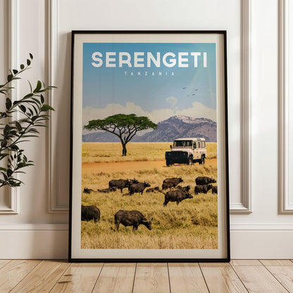 The image is a framed poster of a safari scene in Tanzania, featuring a herd of wildebeest grazing in the foreground and a safari vehicle in the background.