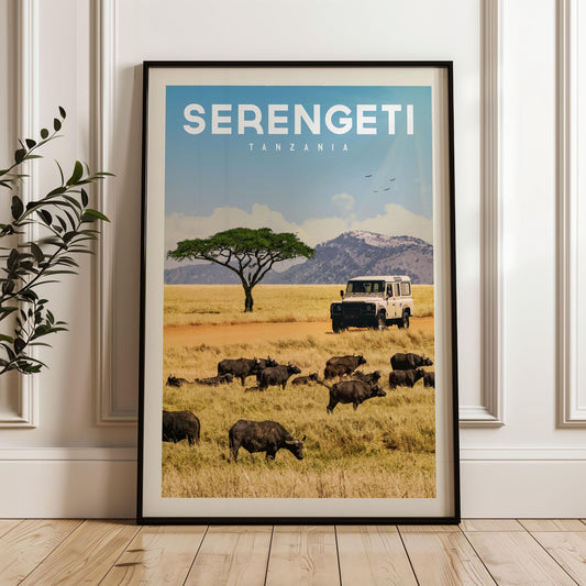 The image is a framed poster of a safari scene in Tanzania, featuring a herd of wildebeest grazing in the foreground and a safari vehicle in the background.